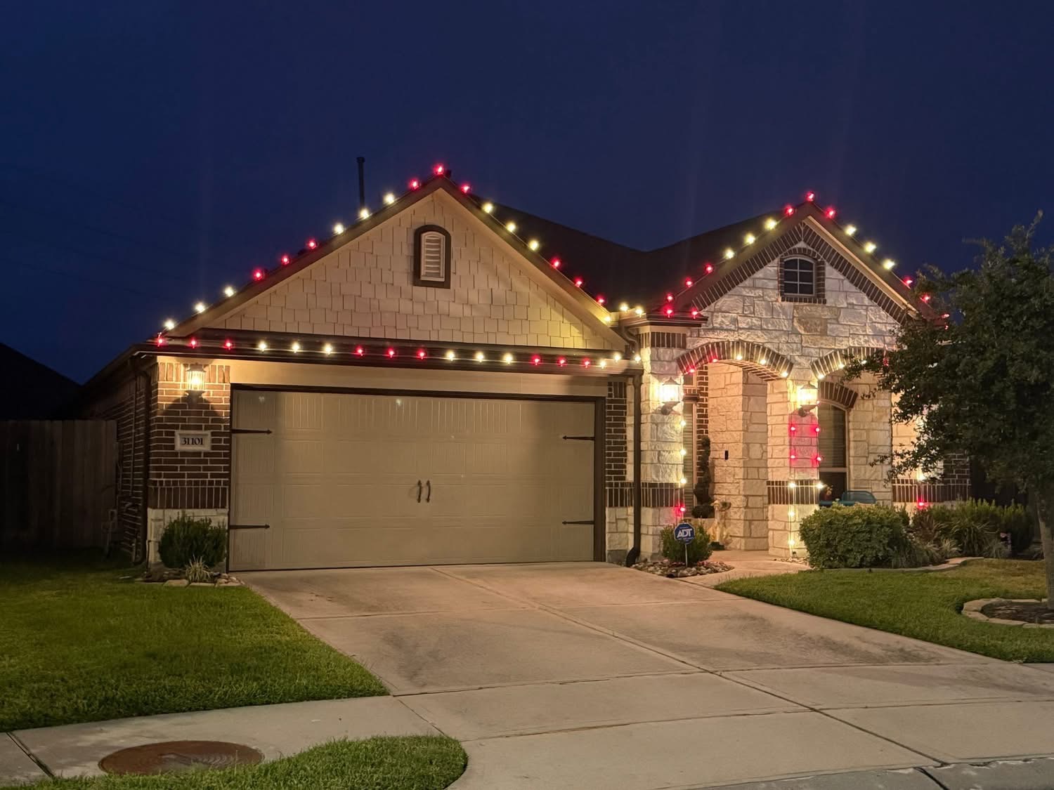 Home with alternating red and warm white Christmas lights on the roofline