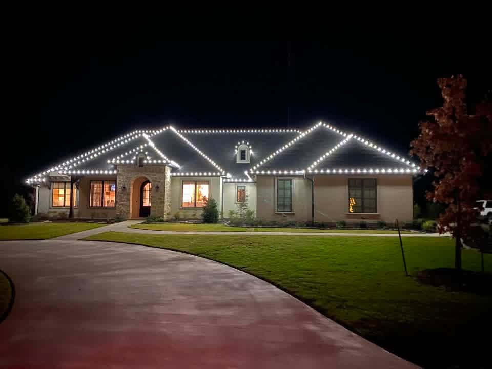 Ranch home outlined in warm white roofline Christmas lights at night